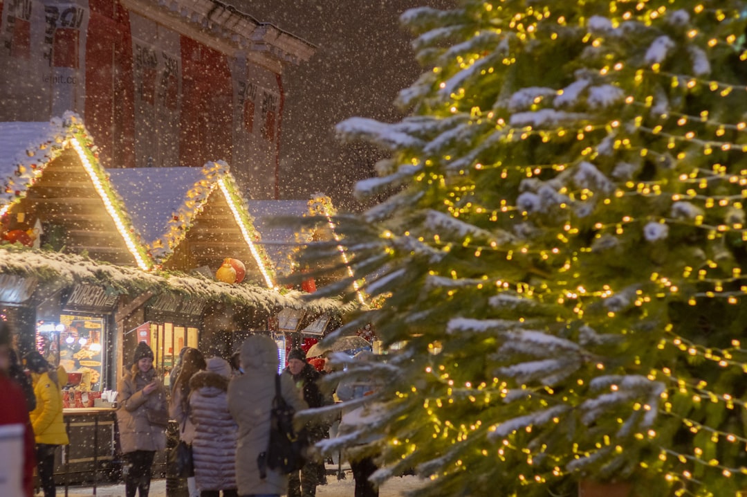 a group of people standing around a christmas tree,