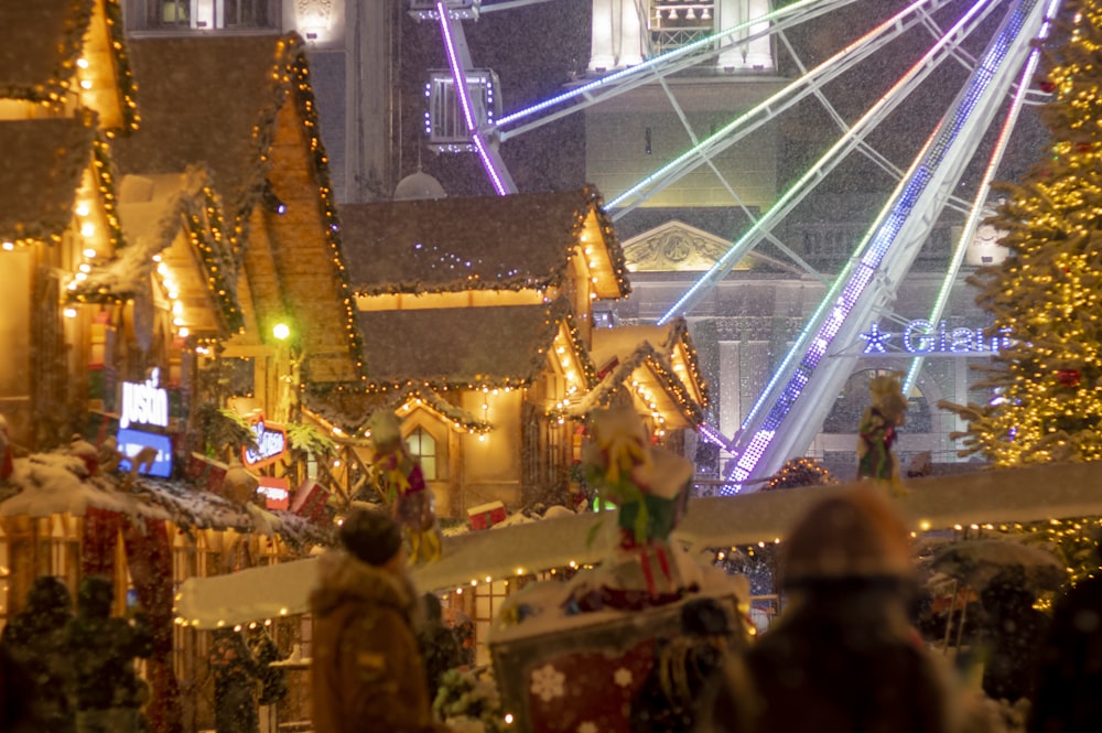 a crowd of people walking down a street covered in christmas lights