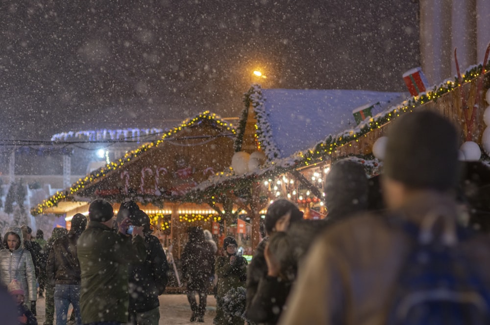 a crowd of people walking down a snow covered street