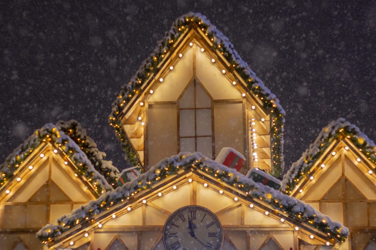 Snowy gable roofline trimmed with warm white Christmas lights