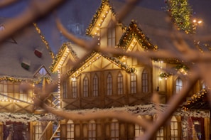 A cozy Christmas card featuring a snowy village scene with twinkling lights.