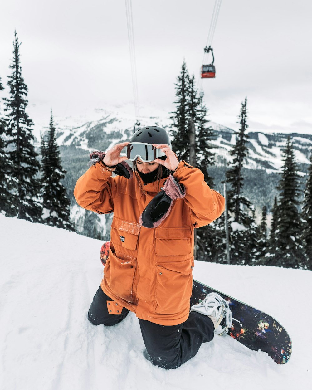 a man sitting in the snow with a snowboard