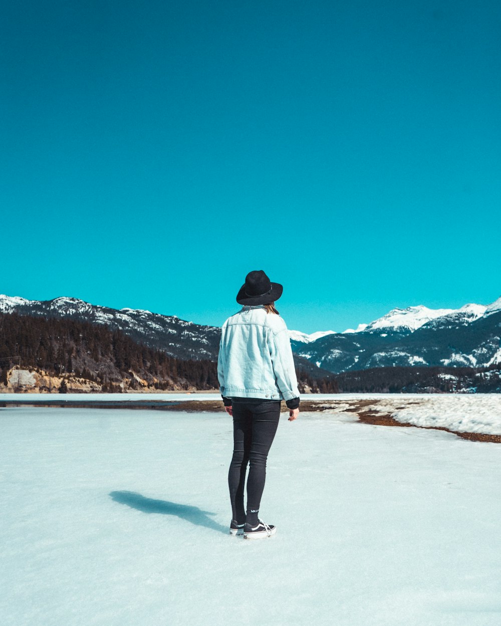 a person standing in the middle of a snow covered field