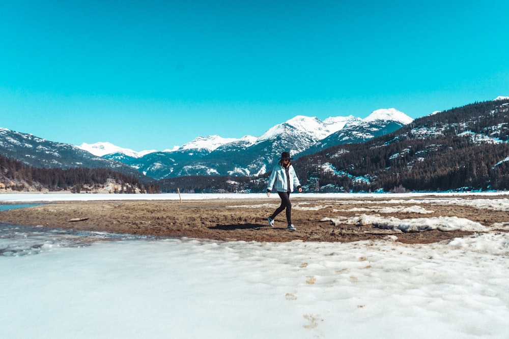 a person standing in a field with mountains in the background