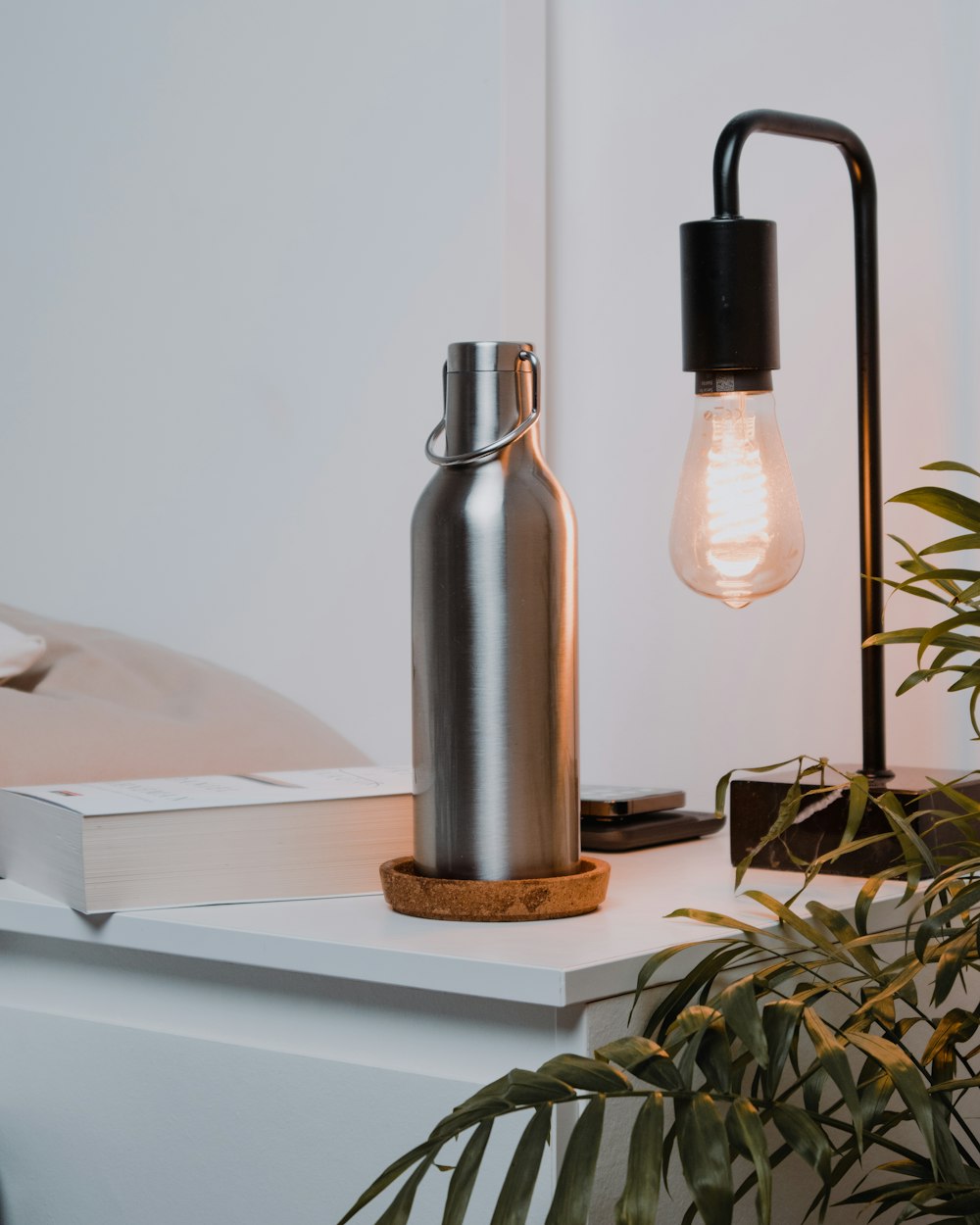 a table with a lamp and a book on it