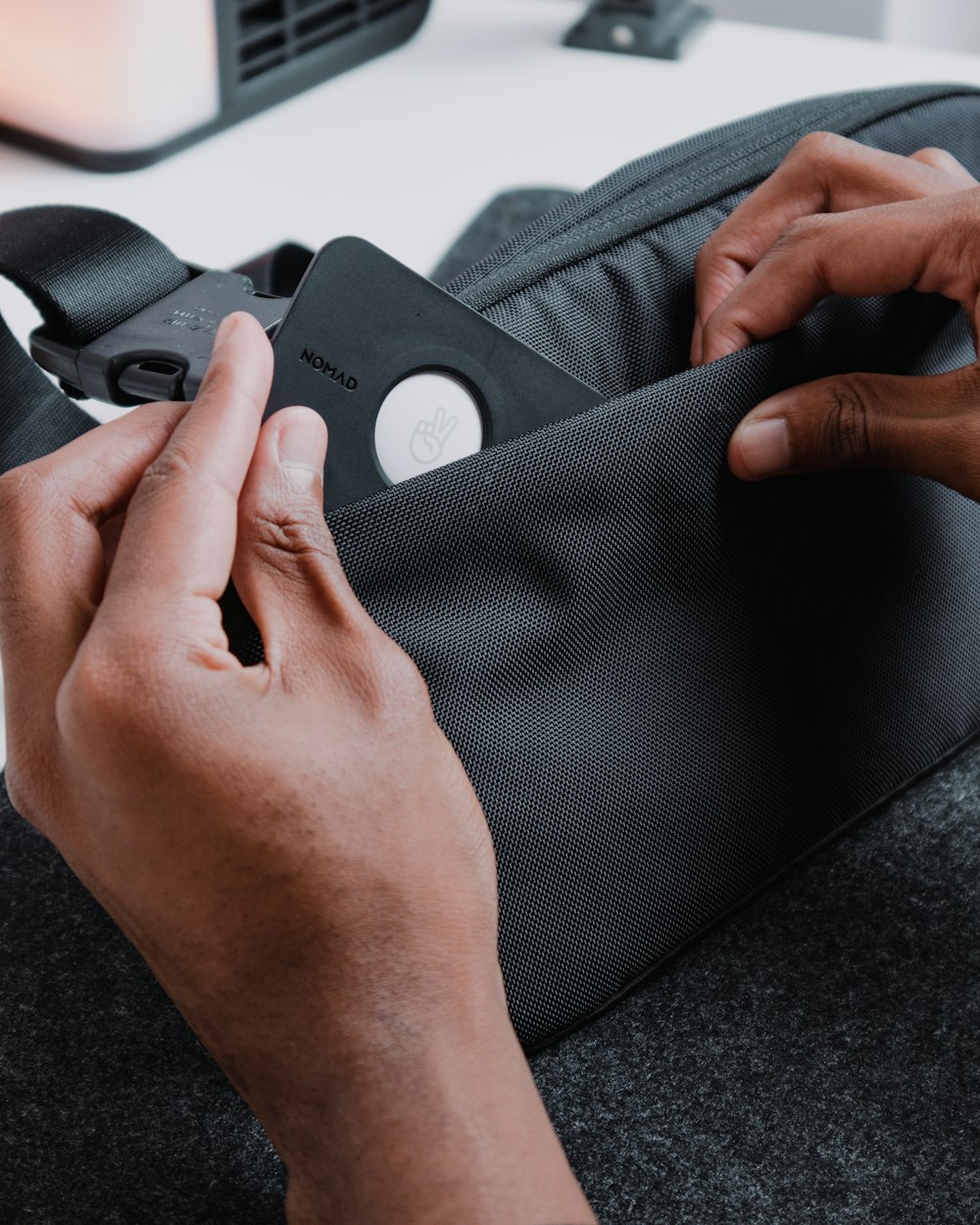 a person is holding a black case on a table