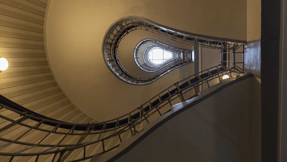 a spiral staircase in a building with a circular window