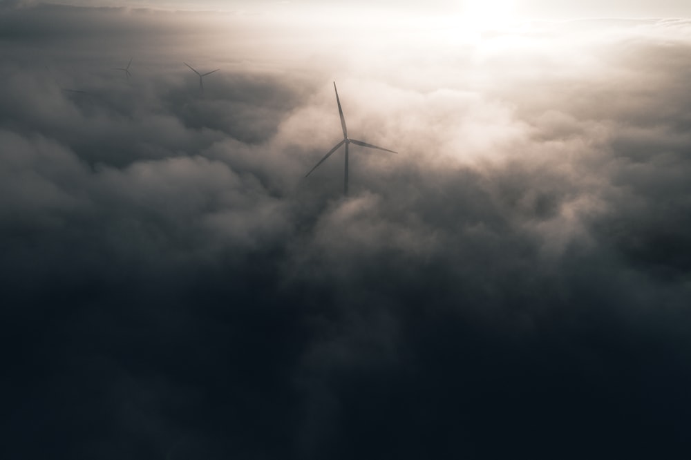 a wind turbine in the middle of a foggy sky
