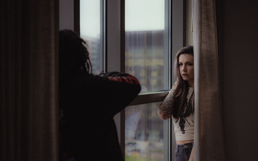 a woman looking out of a window at another woman