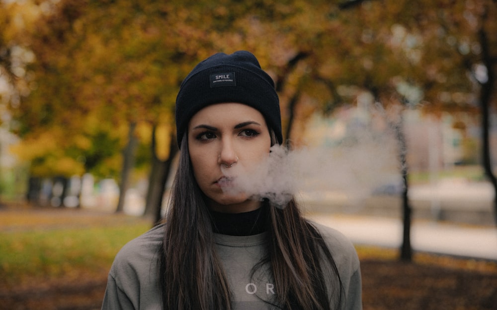 a woman smoking a cigarette in a park