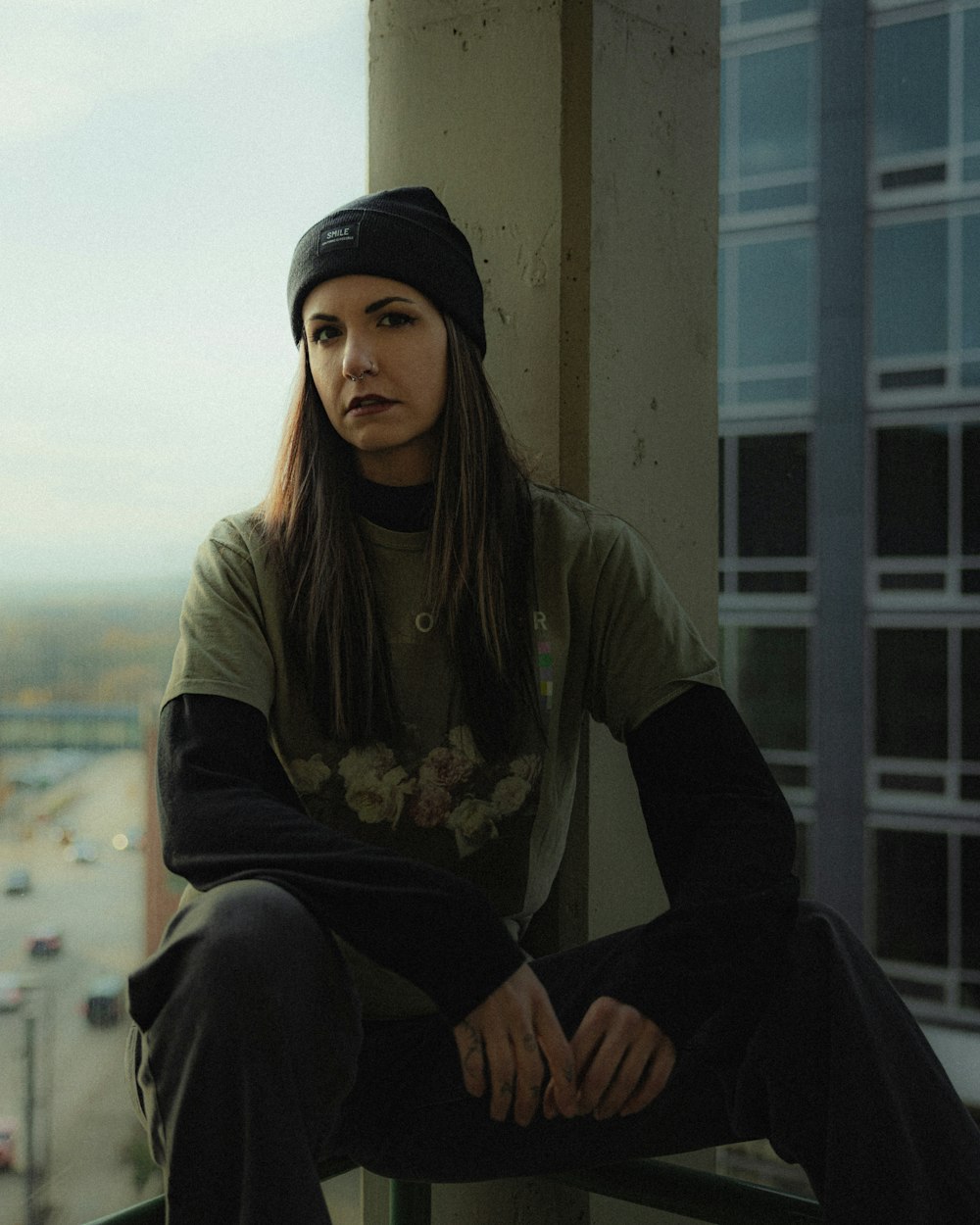 a woman sitting on a ledge with her hands on her knees