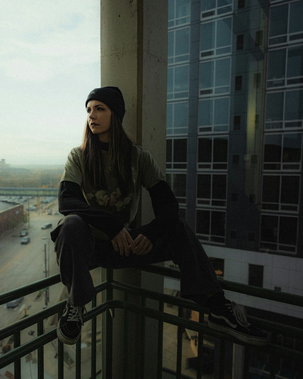 a person sitting on a balcony with a skateboard