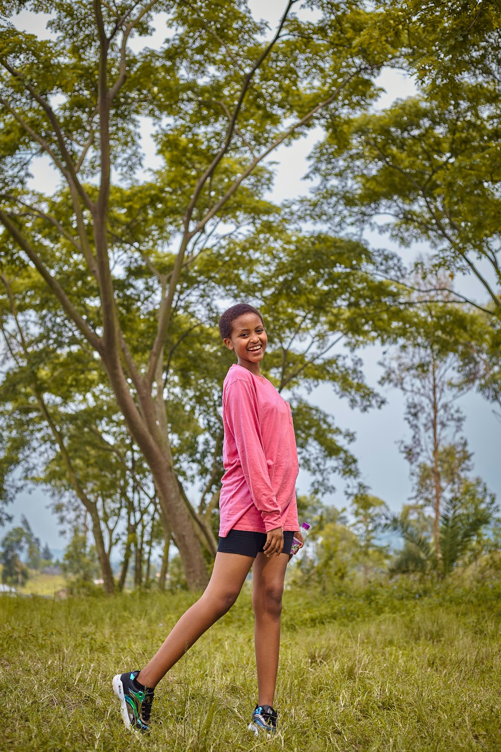 a girl in a pink shirt is playing frisbee