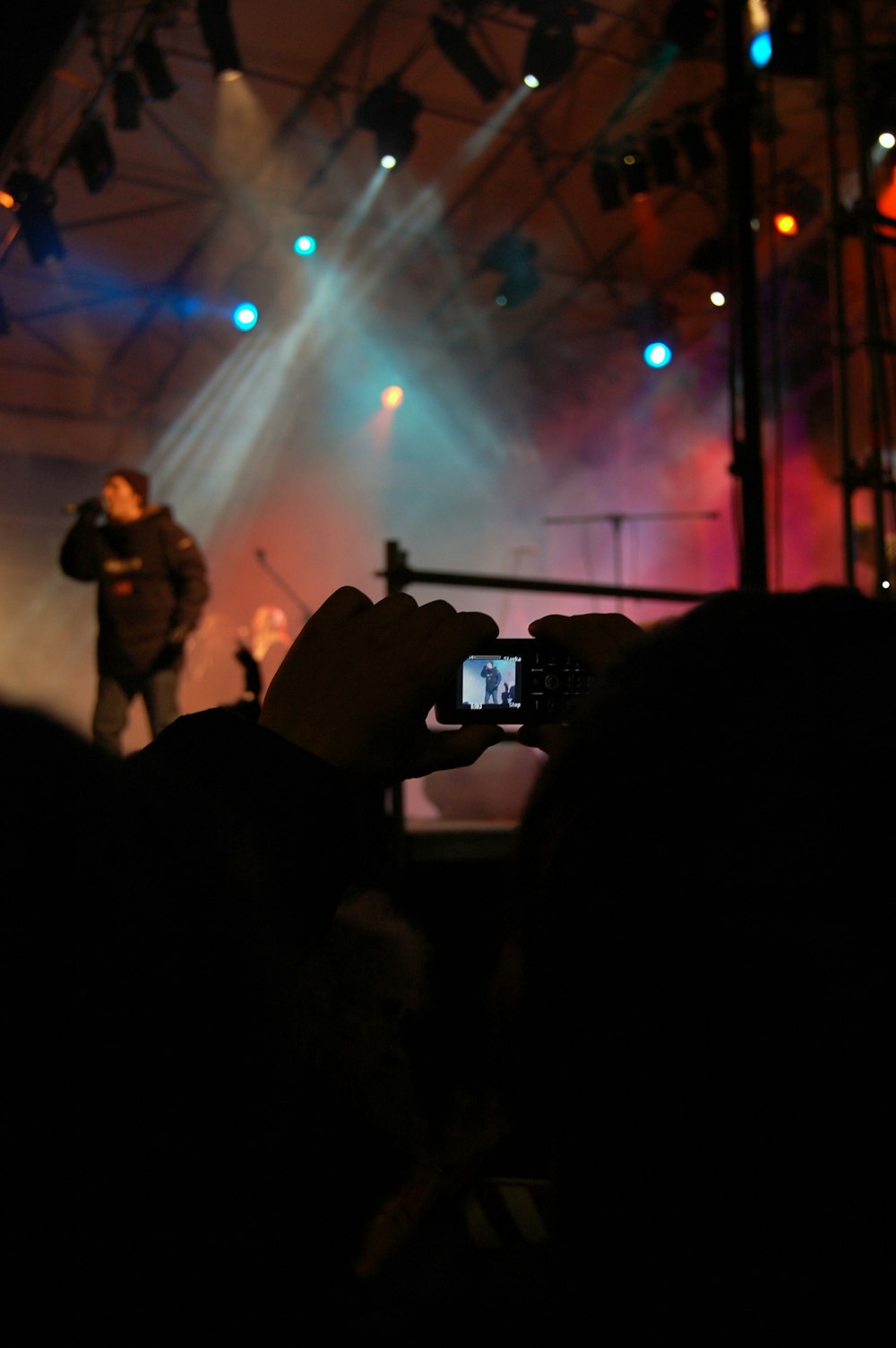 a person taking a picture of a concert with a cell phone