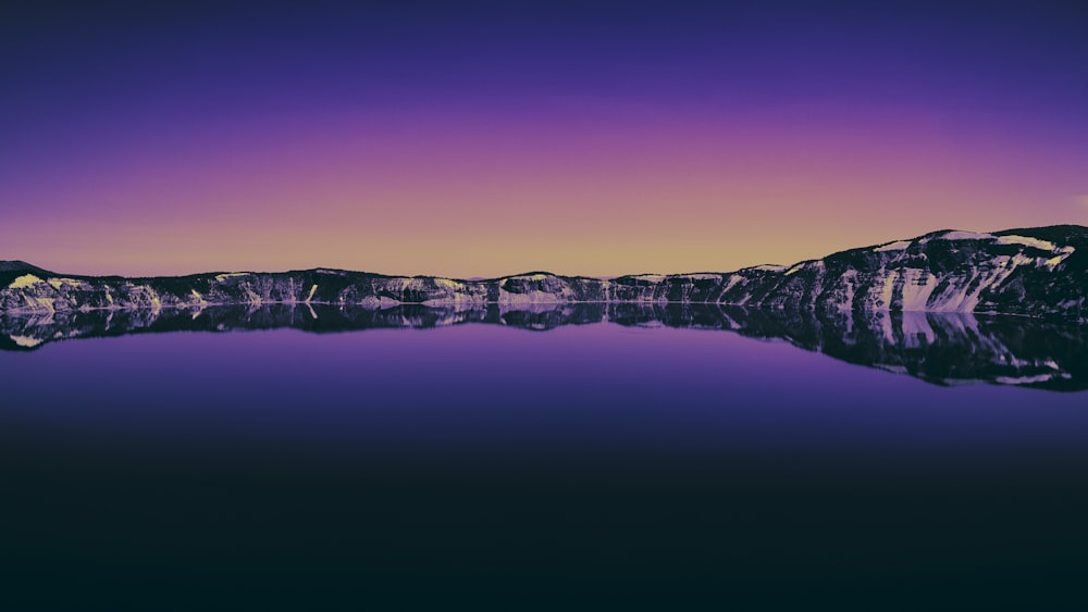 a mountain range is reflected in the water