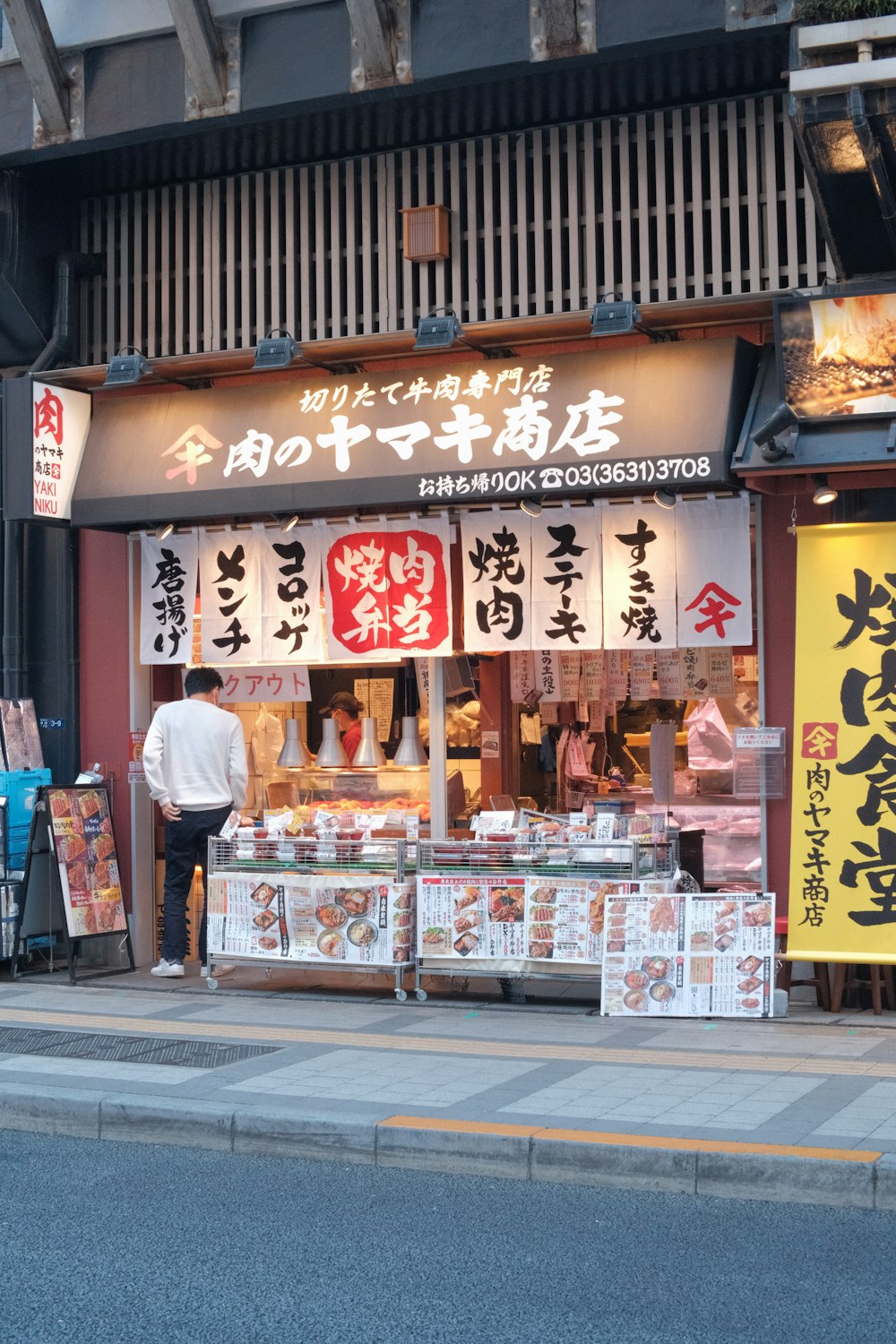 a man standing in front of a food stand