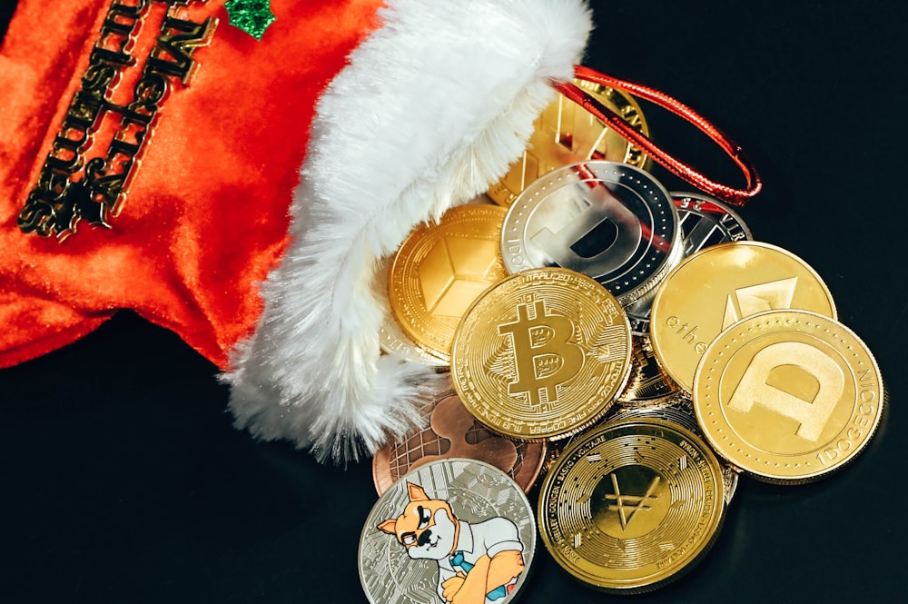Eine Weihnachtsmannmütze und einige Bitcoins auf einem Tisch