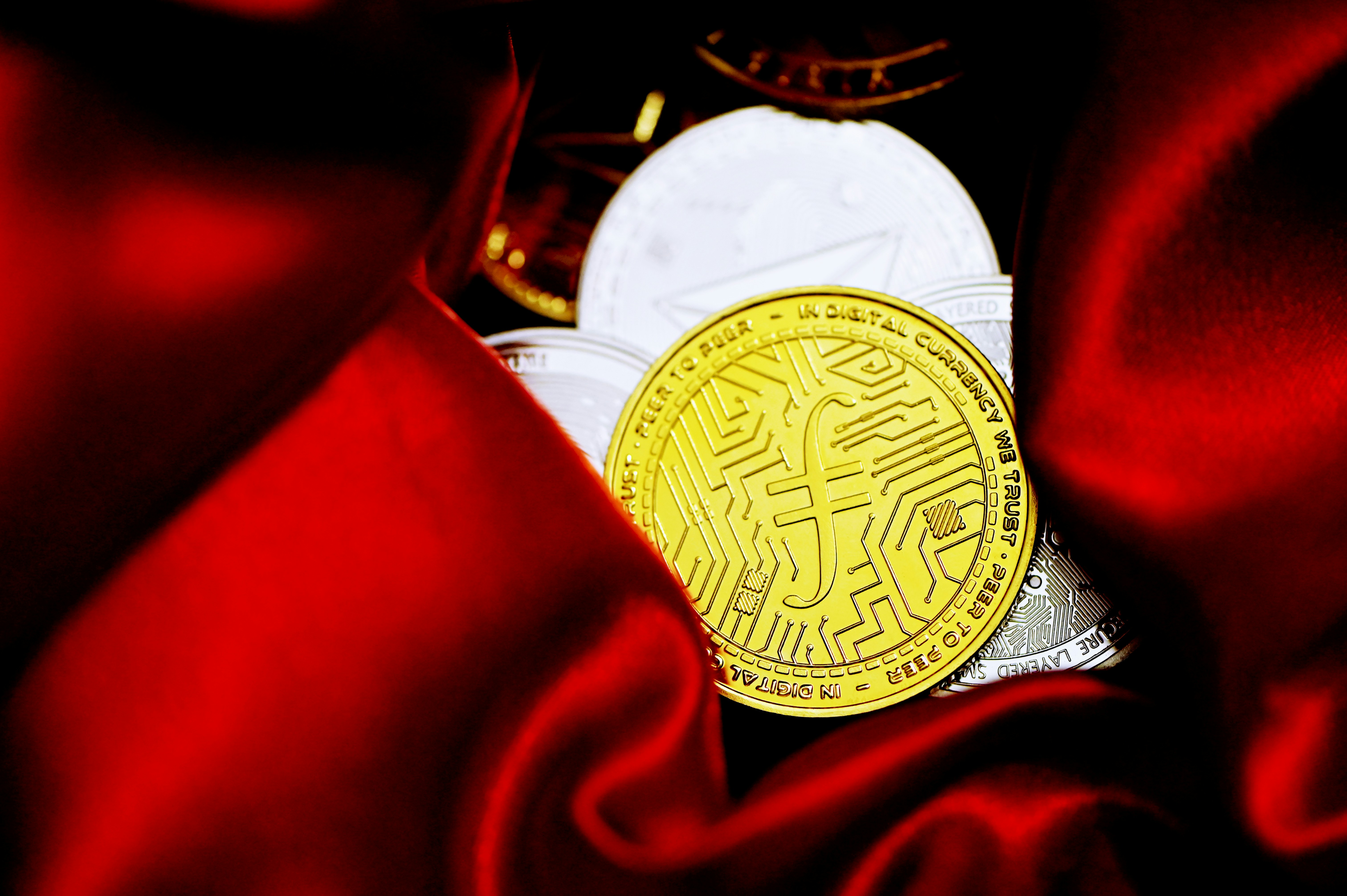 A gold Filecoin on red velvet