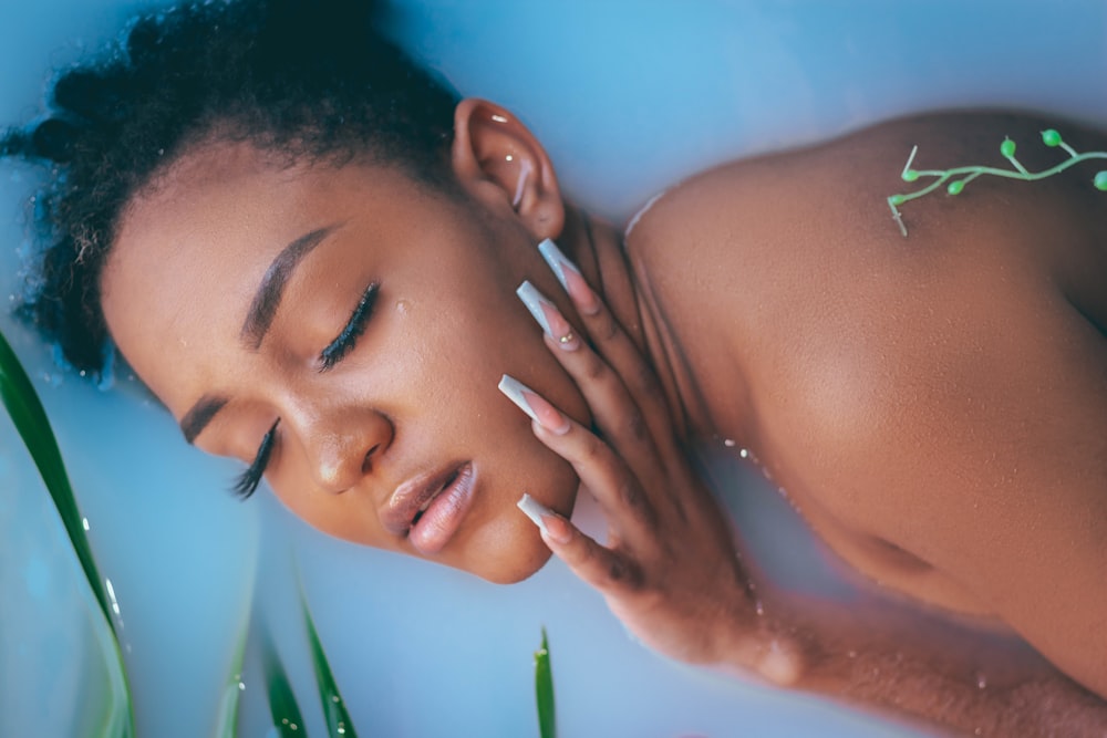 a woman laying in a bathtub with her eyes closed