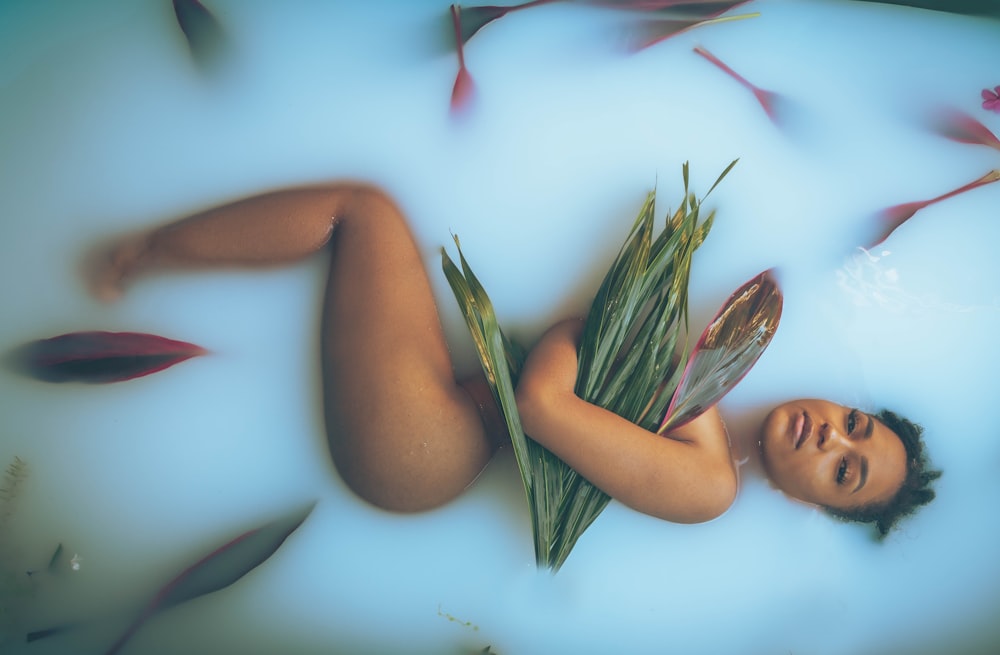 a woman laying on the ground with a bunch of flowers