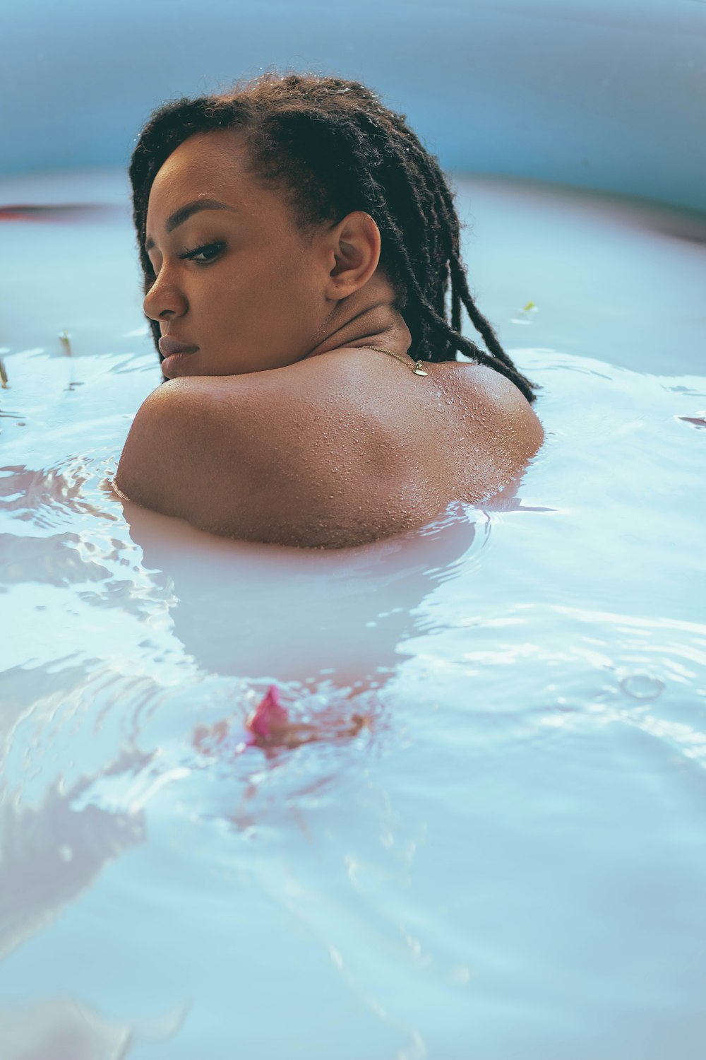 a woman with dreadlocks in a pool of water