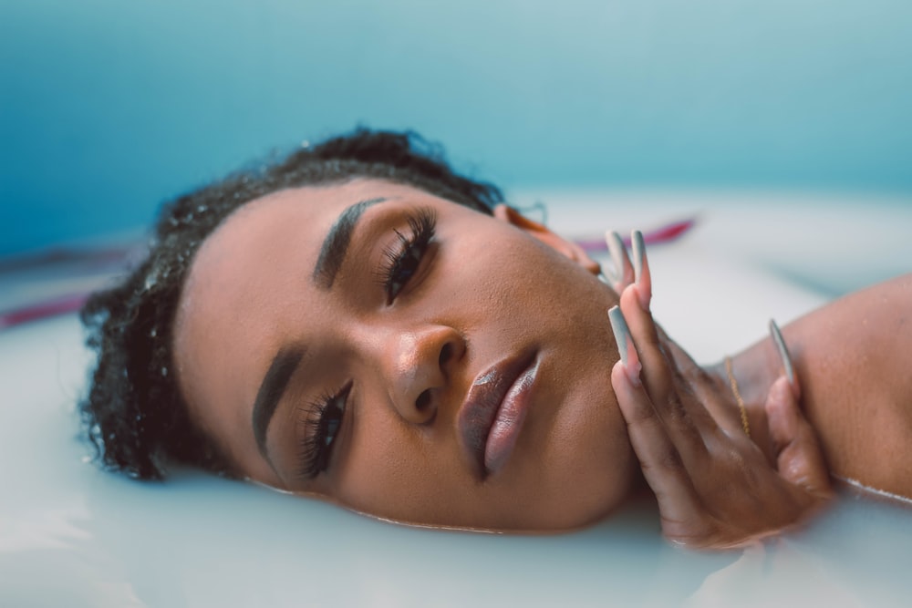 a woman is laying down with a cigarette in her hand