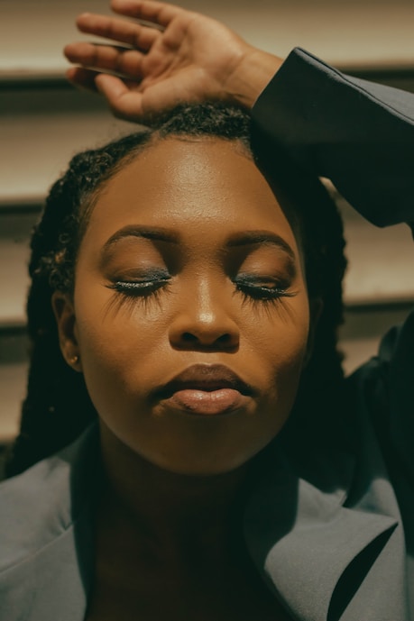 a close up of a woman with her hands on her head