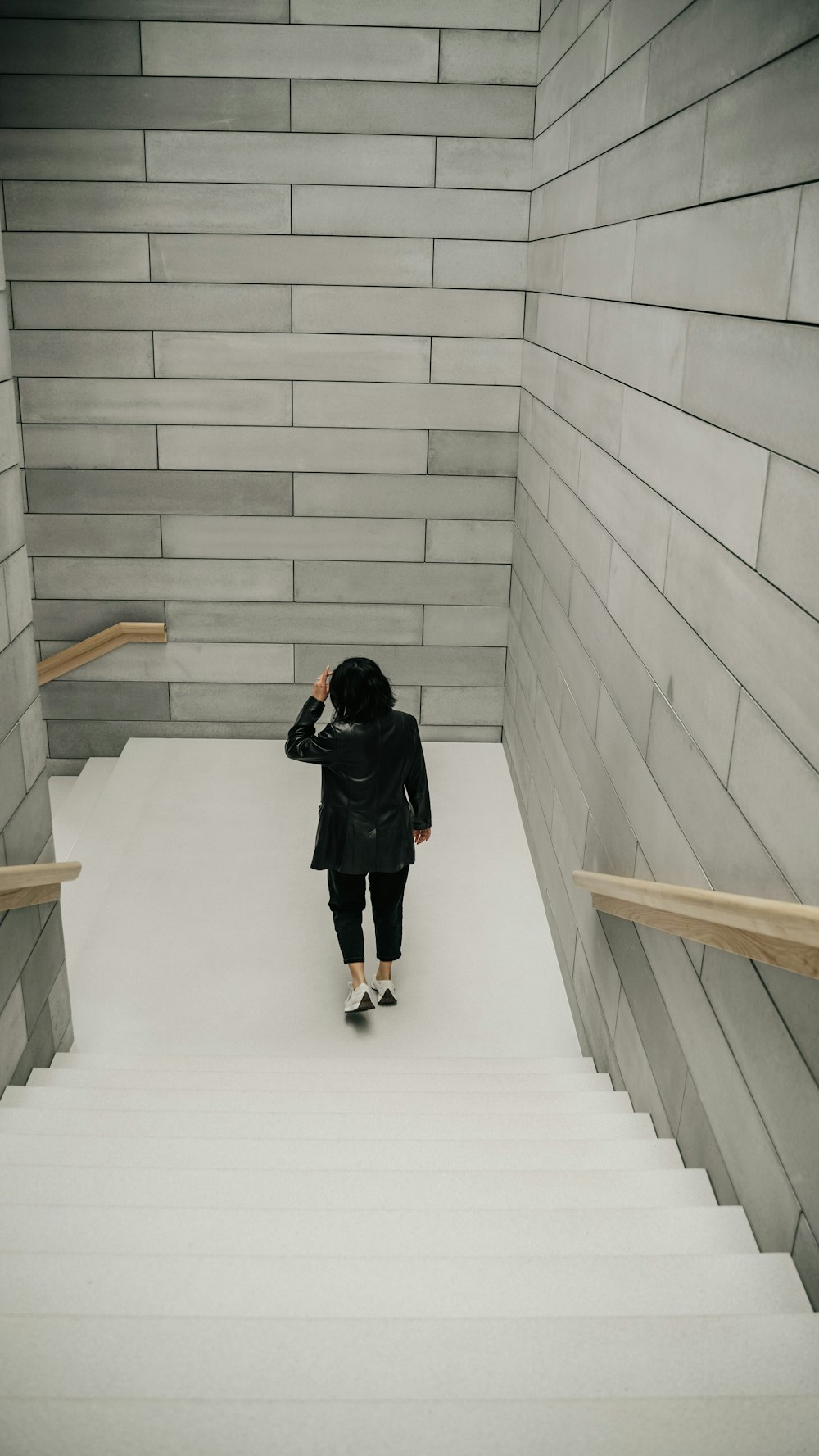 a person in a black jacket is walking up some stairs