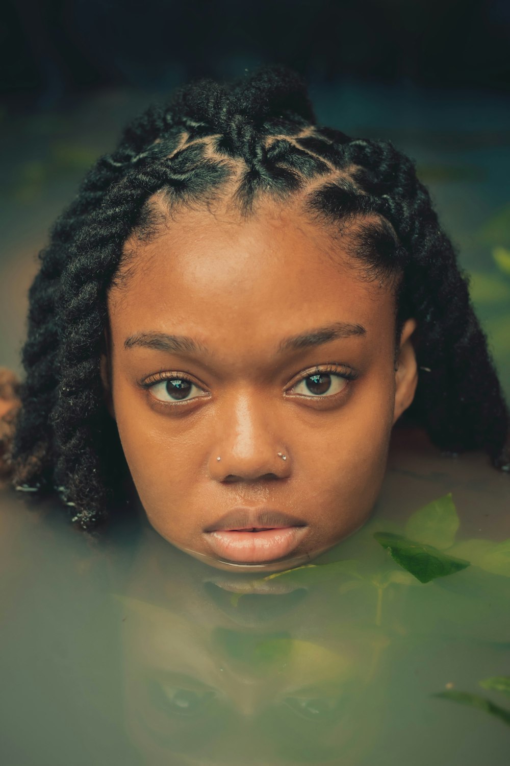 a woman with braids in a pool of water