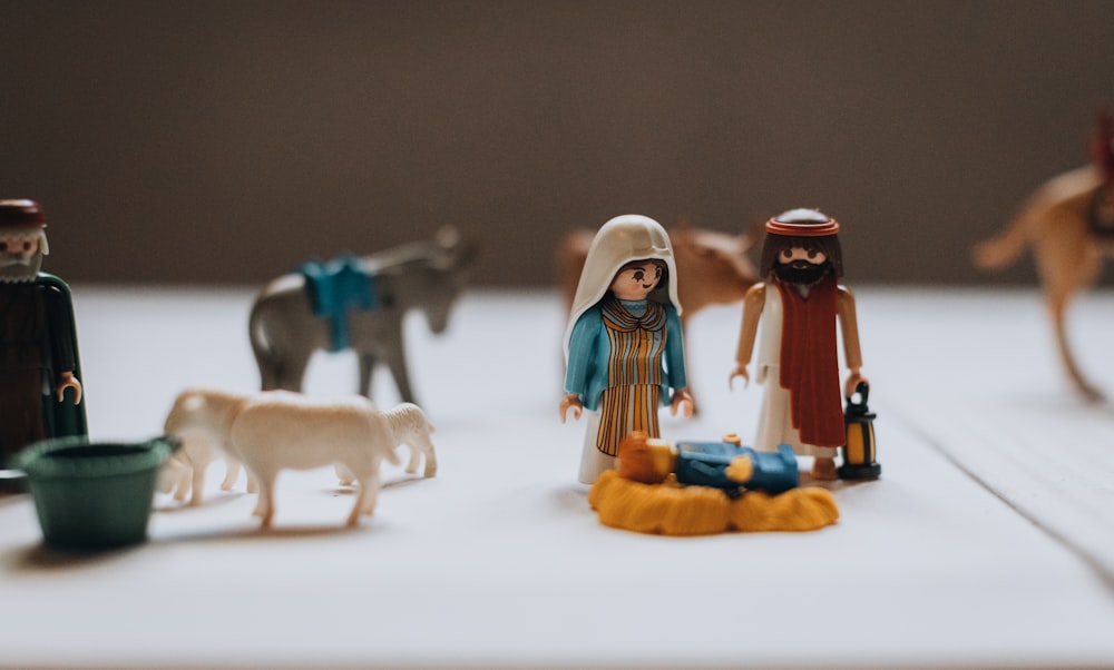 a table topped with figurines of people and animals