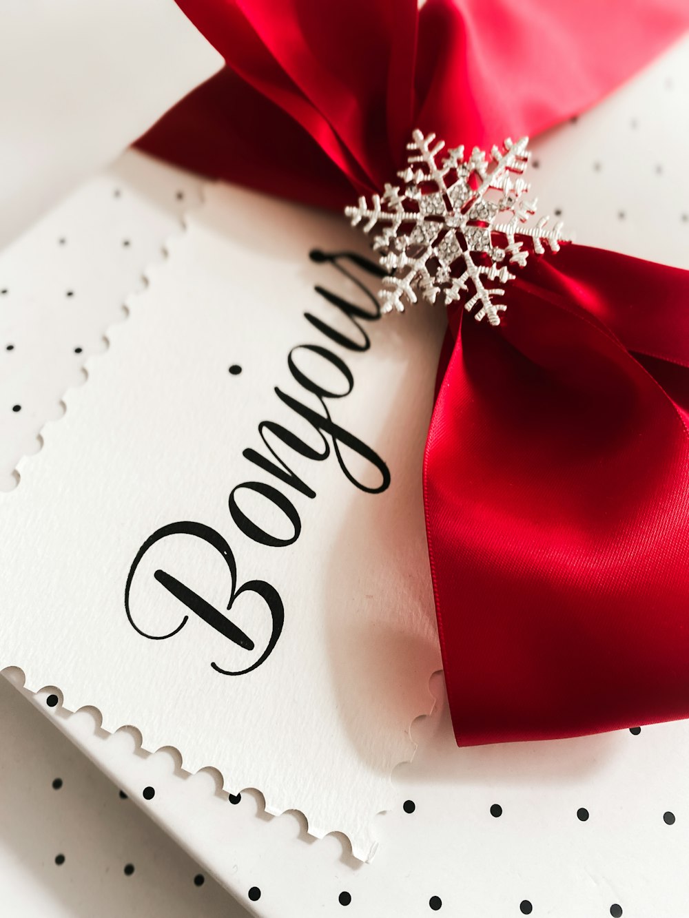 a close up of a red bow on a card