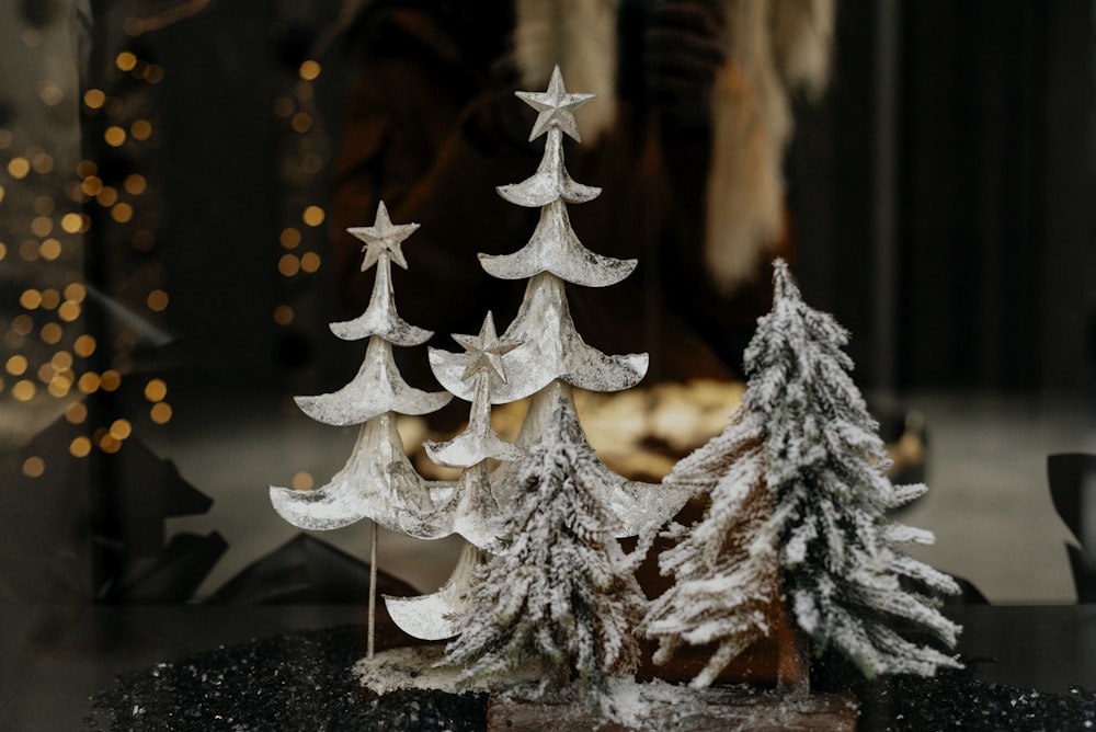 a couple of small white trees sitting on top of a table