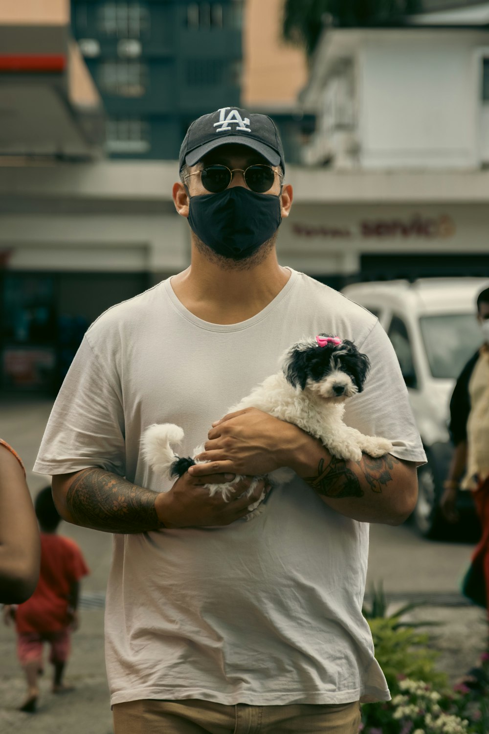 a man wearing a face mask holding a small dog