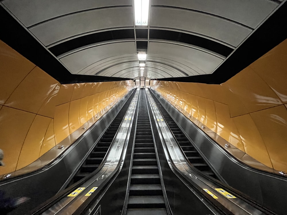 an escalator in a subway station with yellow walls