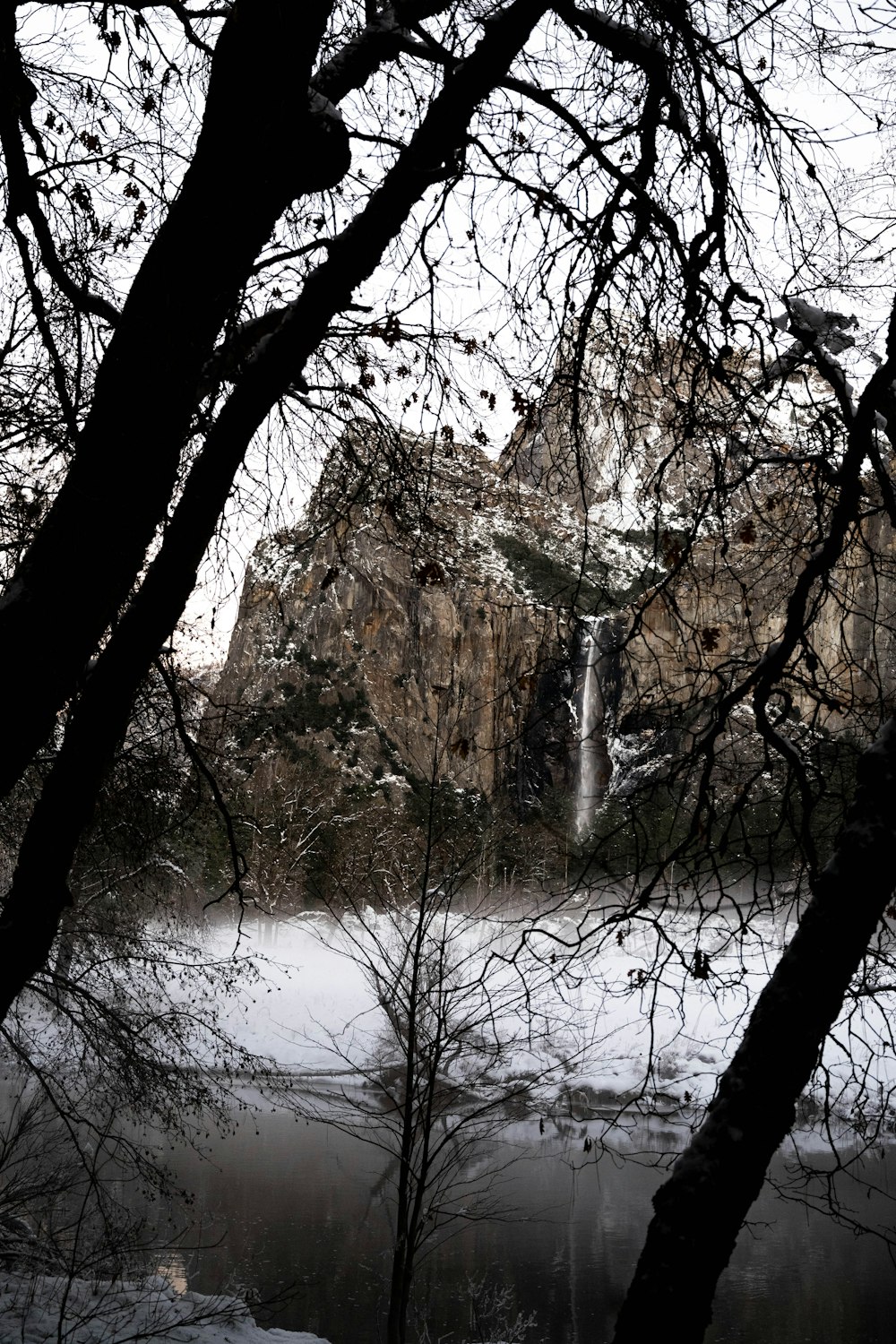 a view of a waterfall through some trees