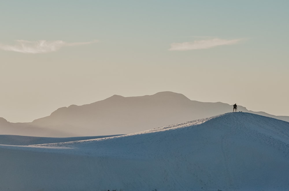 雪に覆われた丘の上に立つ人