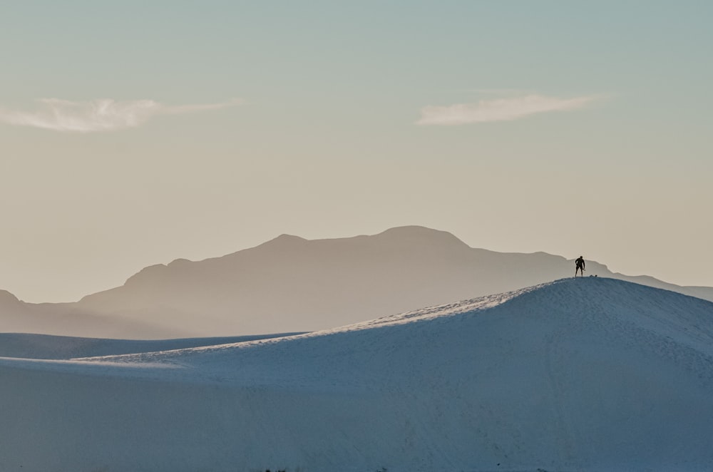 a person standing on top of a snow covered hill