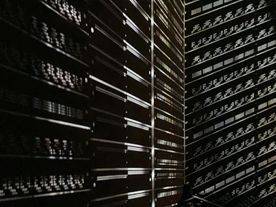 A softly lit server room with rows of sleek black servers glowing with blue indicator lights.