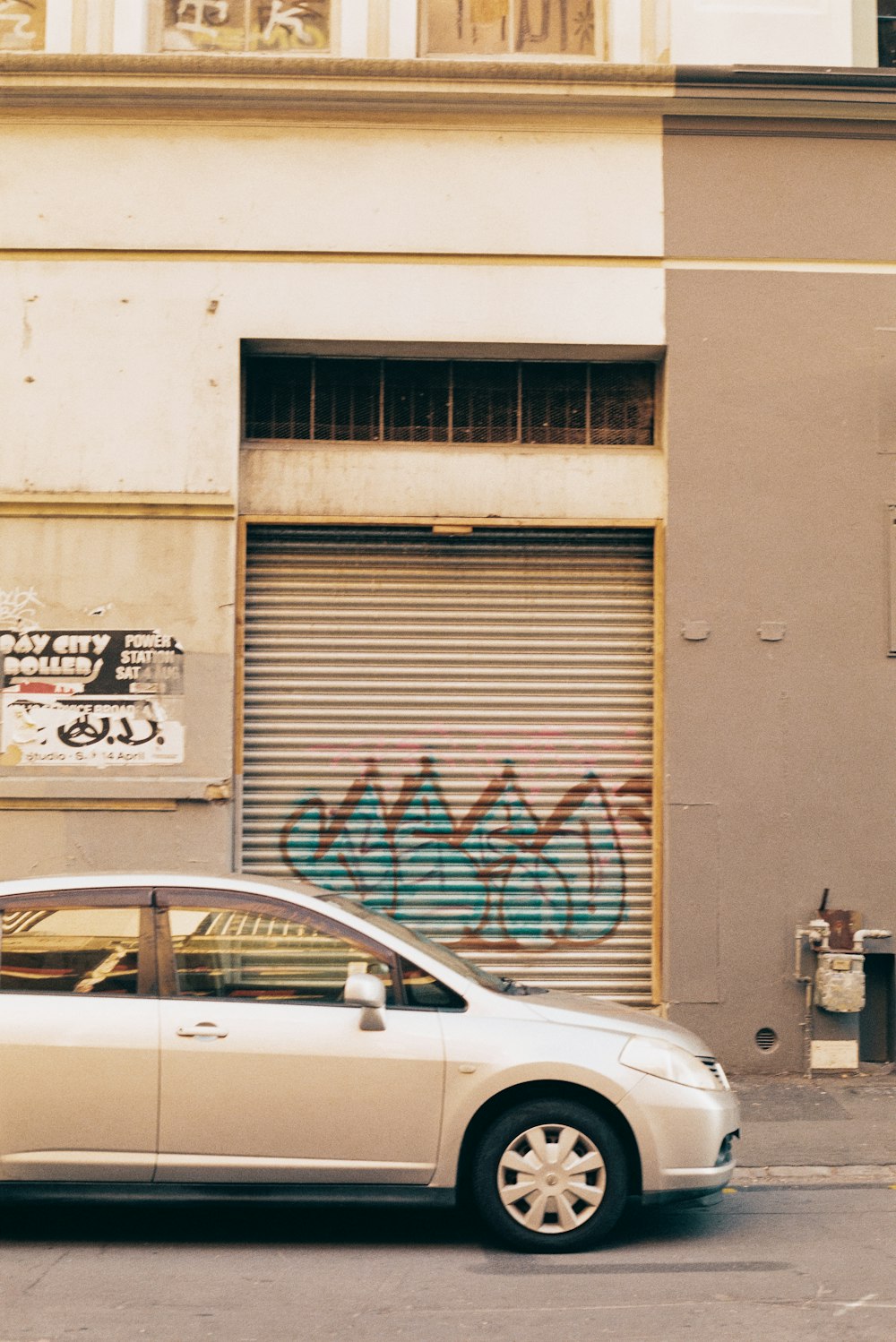 a car parked in front of a building with graffiti on it