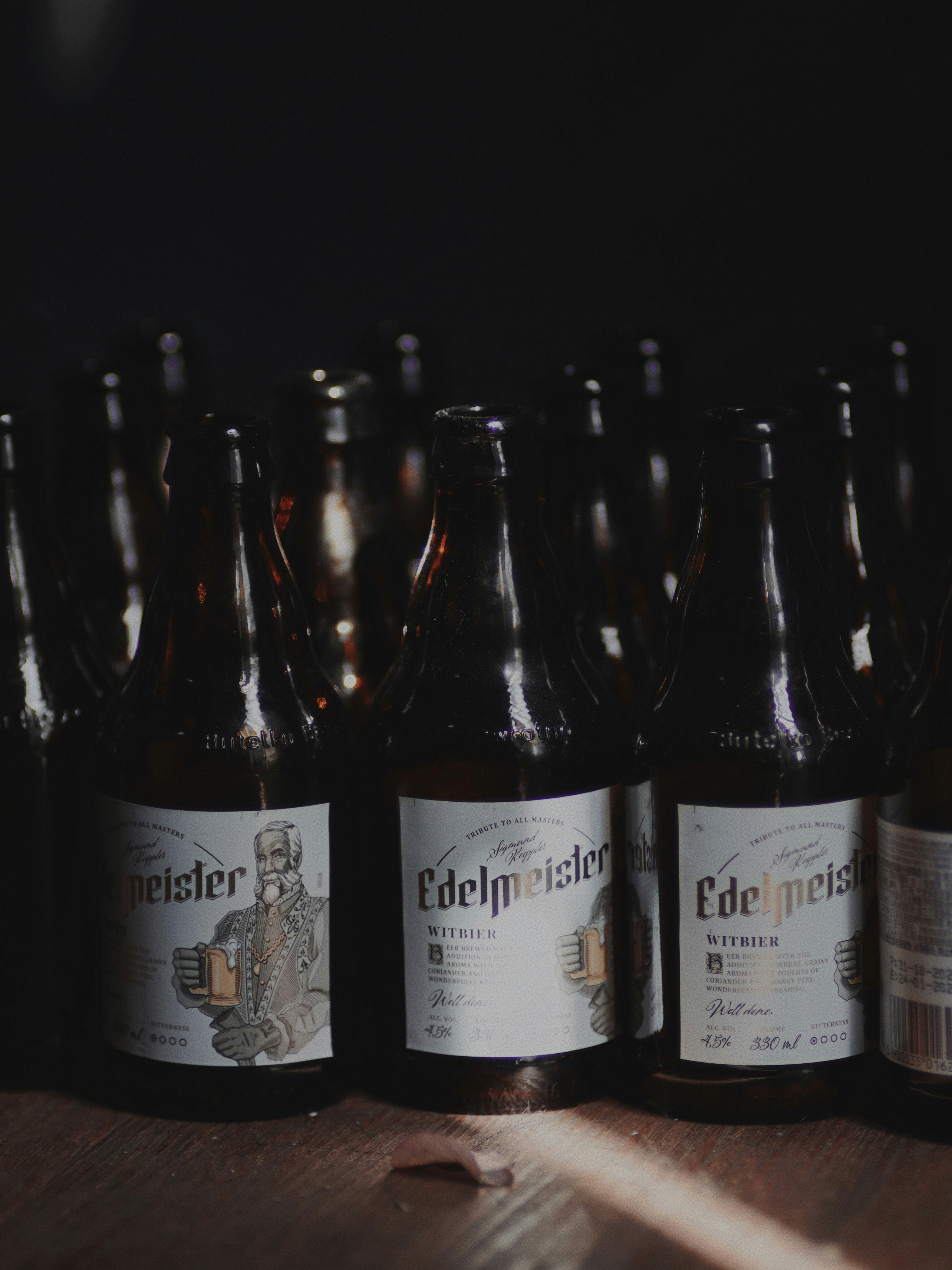 A group of bottles of beer sitting on top of a wooden table photo