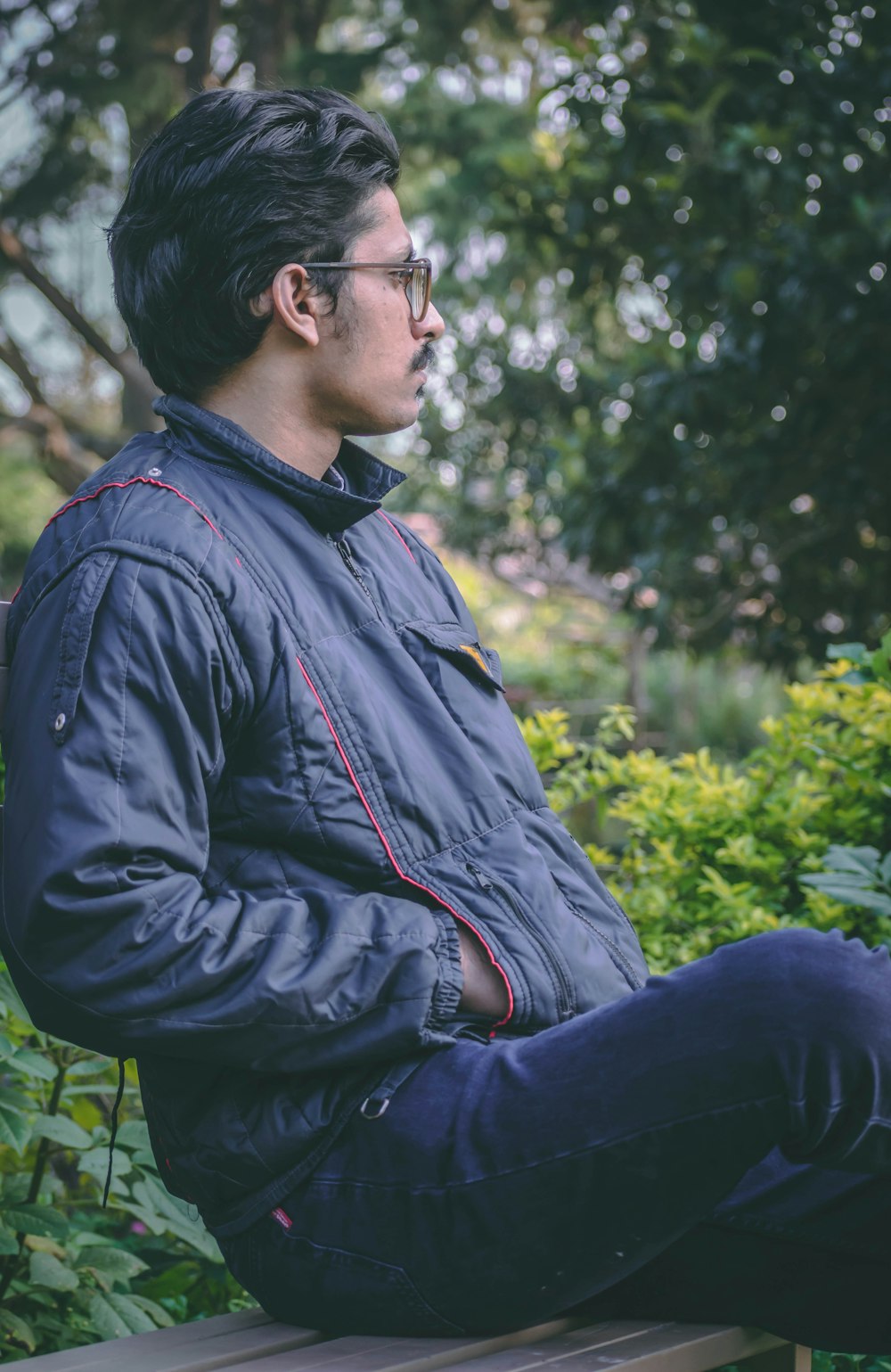 a man sitting on top of a wooden bench