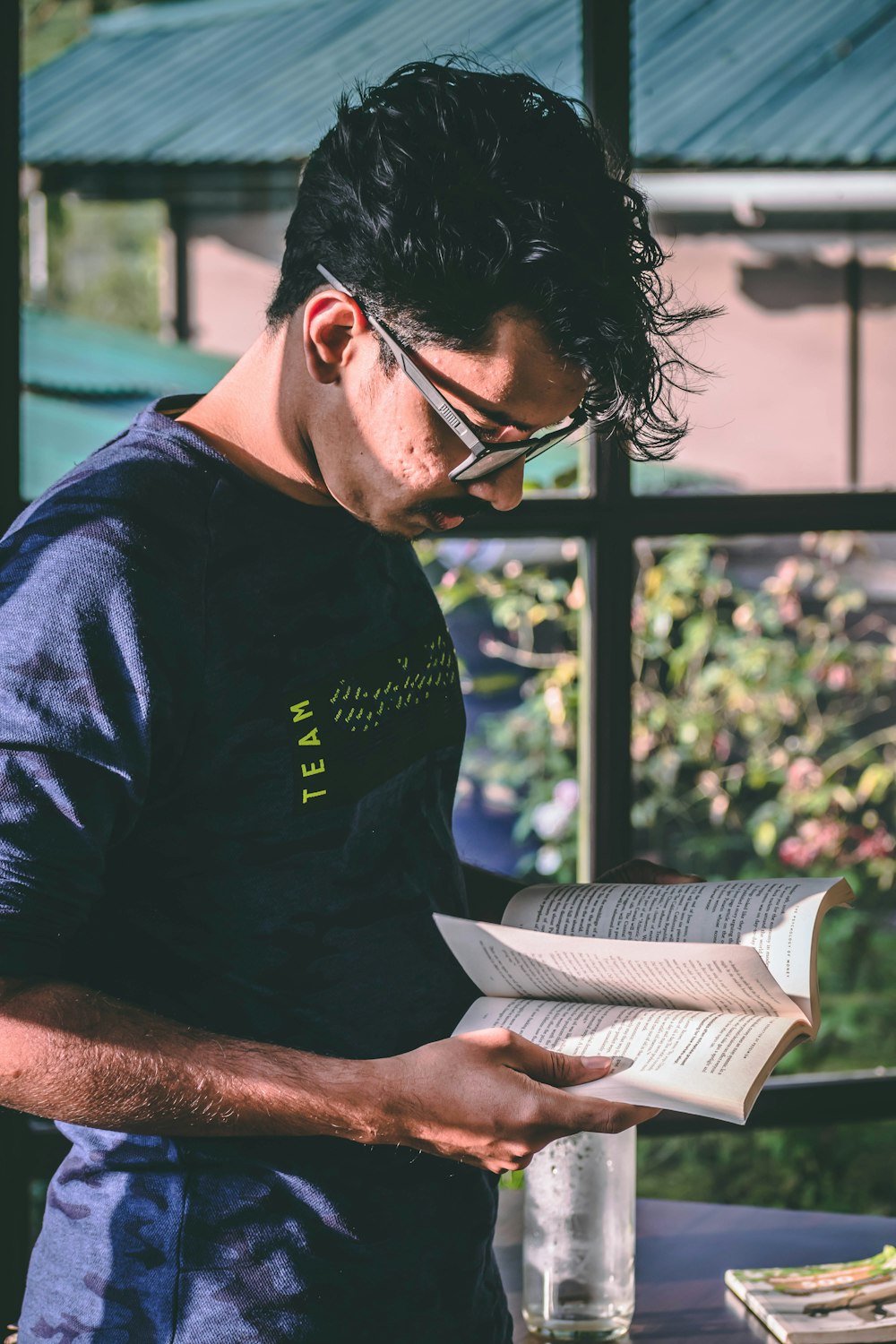 a man is reading a book on a table