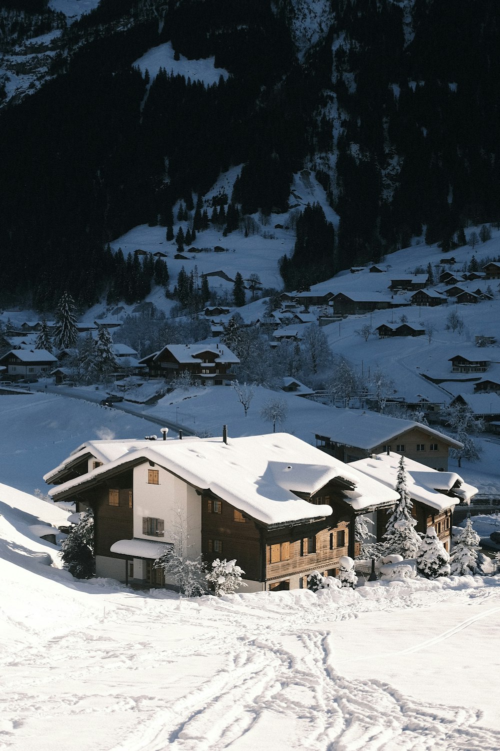 a snow covered ski slope with houses in the background