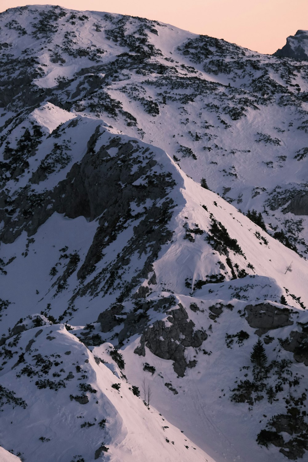 a snow covered mountain with a ski lift in the distance