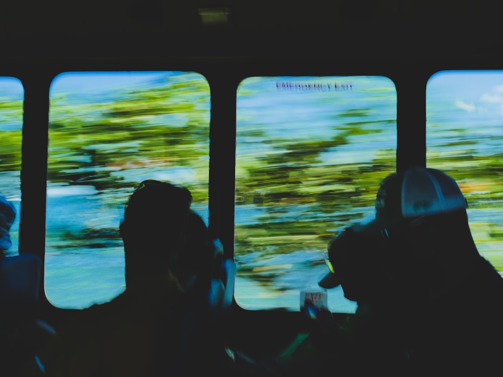 a group of people sitting in a bus looking out the window