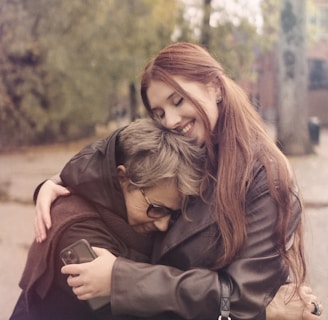 two women hugging each other on a city street