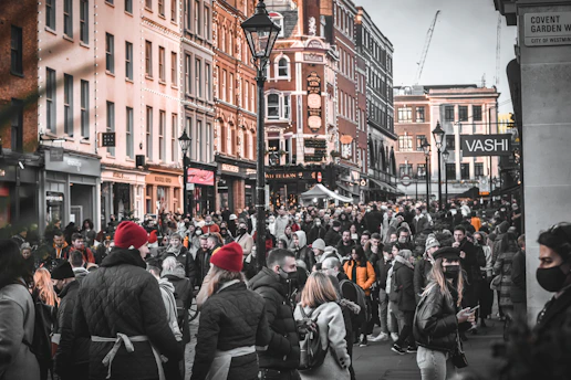 a crowd of people walking down a street next to tall buildings
