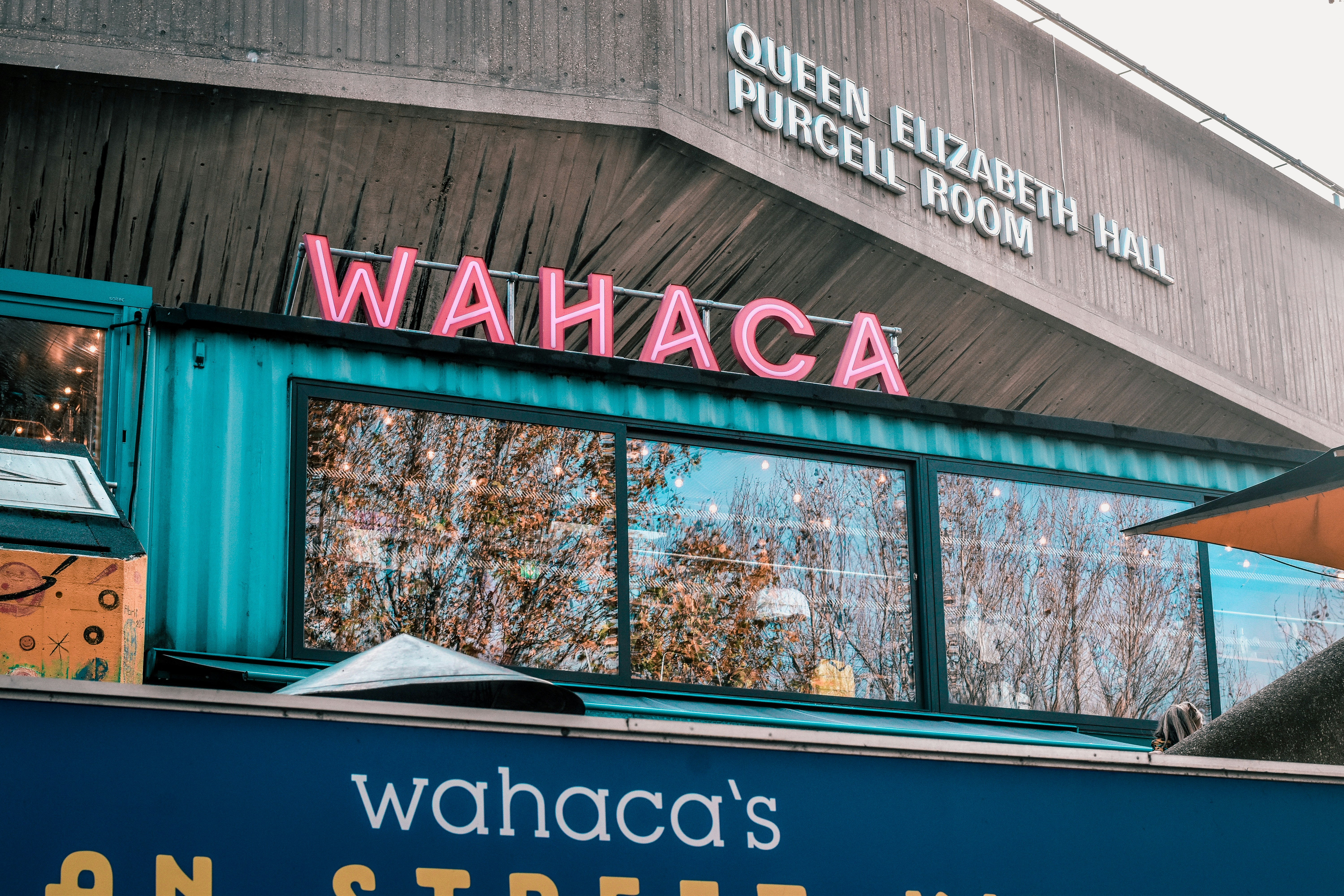 a sign that says wahaca on the side of a building