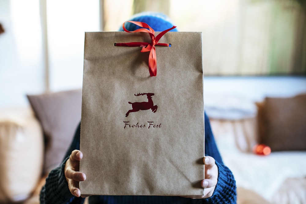 a person holding a brown paper bag with a dog on it