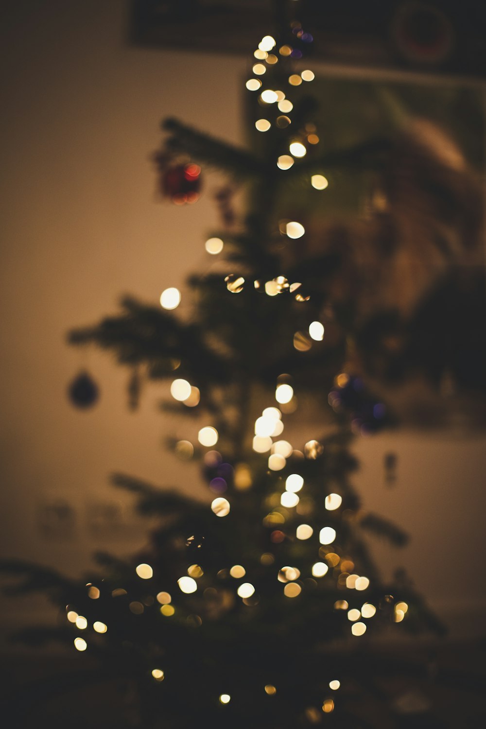 a small christmas tree is lit up in the dark